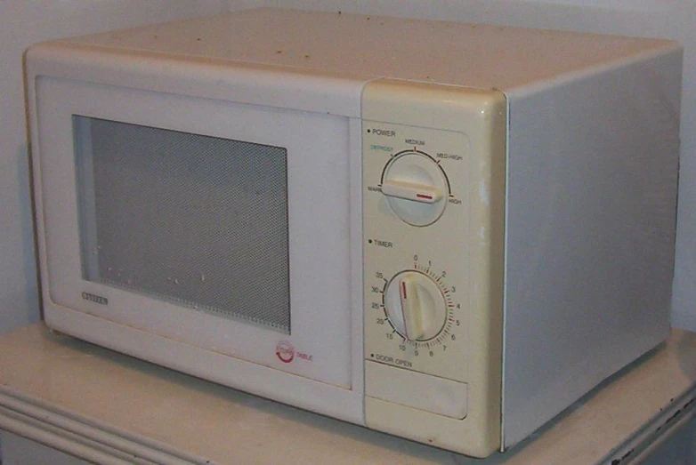 an old microwave sitting on top of a shelf