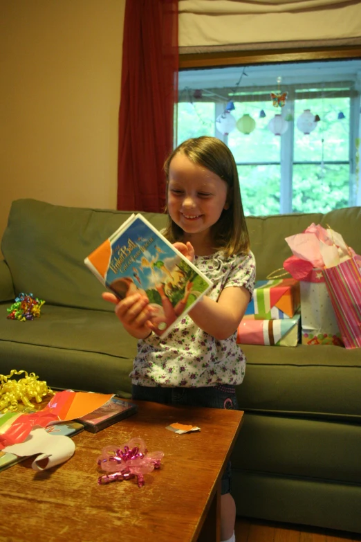 the girl is sitting in her living room with the open book