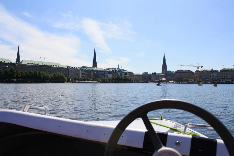 a boat traveling on the river with buildings in the background