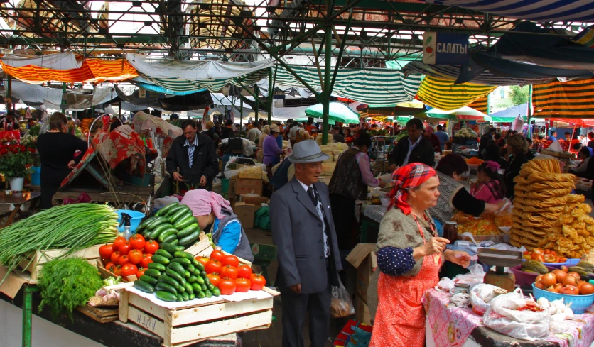 a crowded market area has many fresh fruits and vegetables