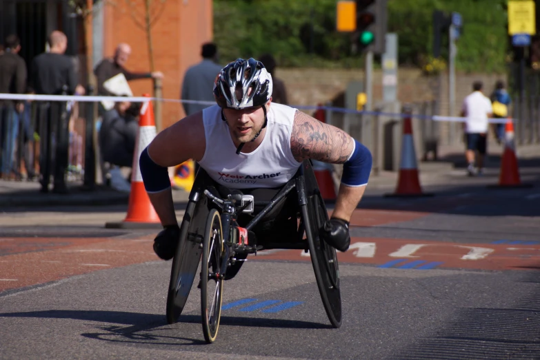 man wearing a triathlon uniform in wheelchair, in a race