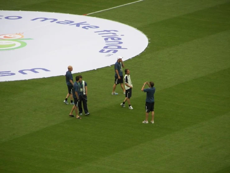 a group of people walking across a grass covered field