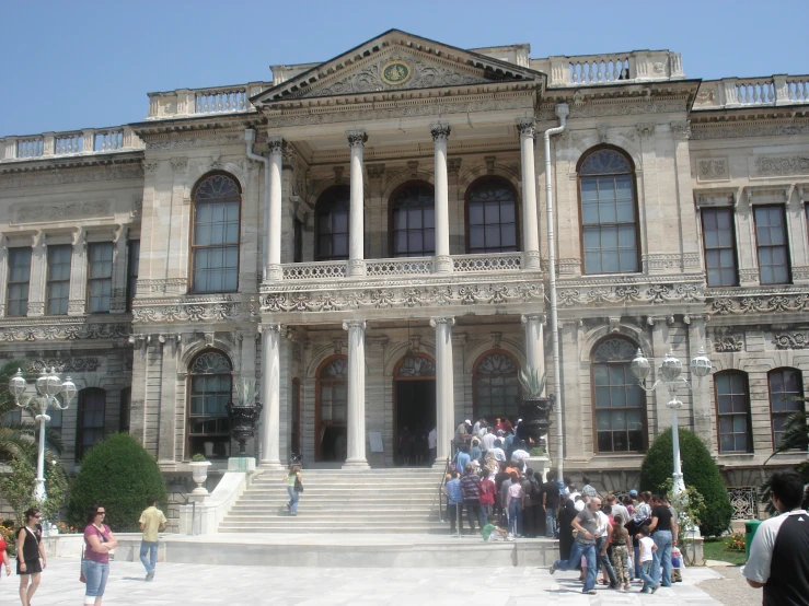 many people outside of a large building