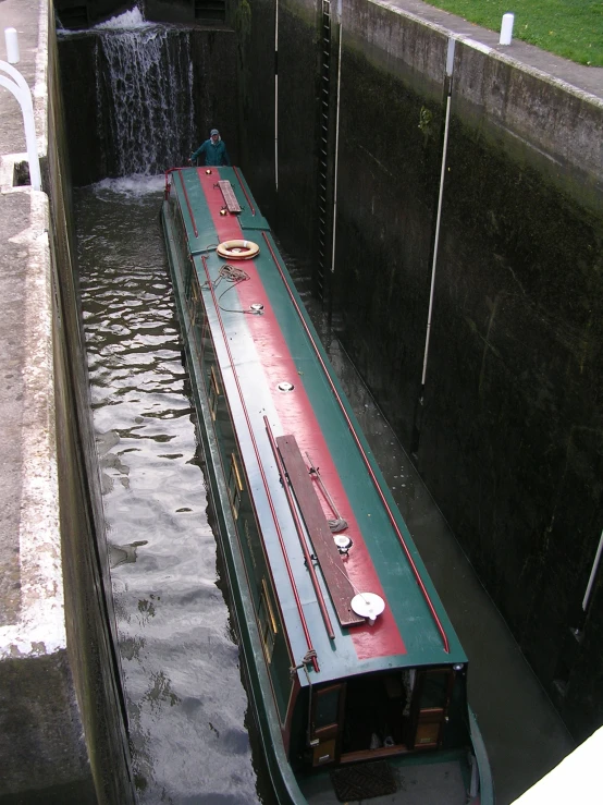 a boat in a channel under a dam