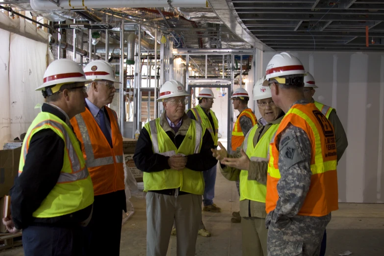 a group of men in safety vests talking to each other