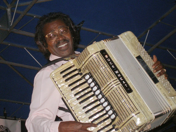 a man with glasses and his instrument is smiling