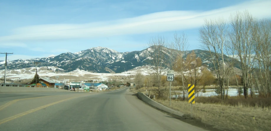 a road with mountains in the background and a street sign