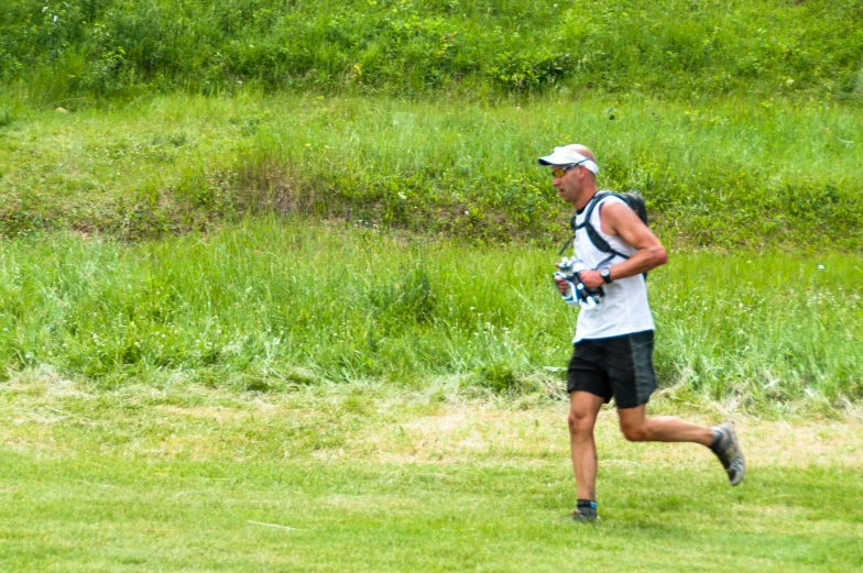 a man running in the grass while wearing a camera