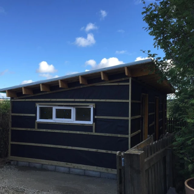 a small house is made out of black wood