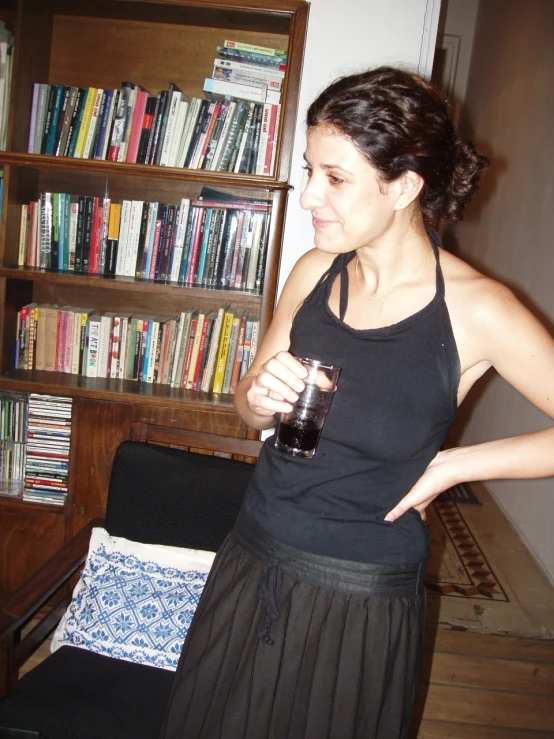 a woman in a black top is holding a cup