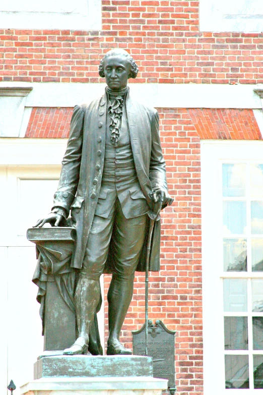 statue of george washington standing in front of a brick building