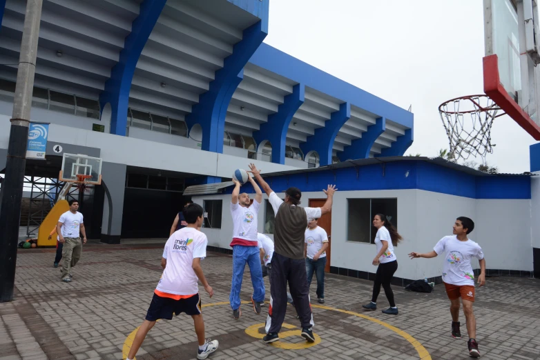 boys and women playing with a disc in a courtyard area