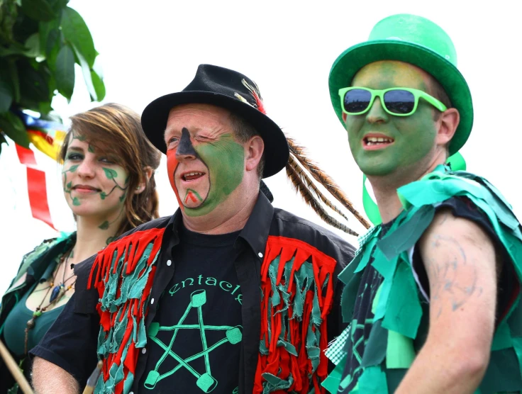 two men and a woman are wearing their face paint