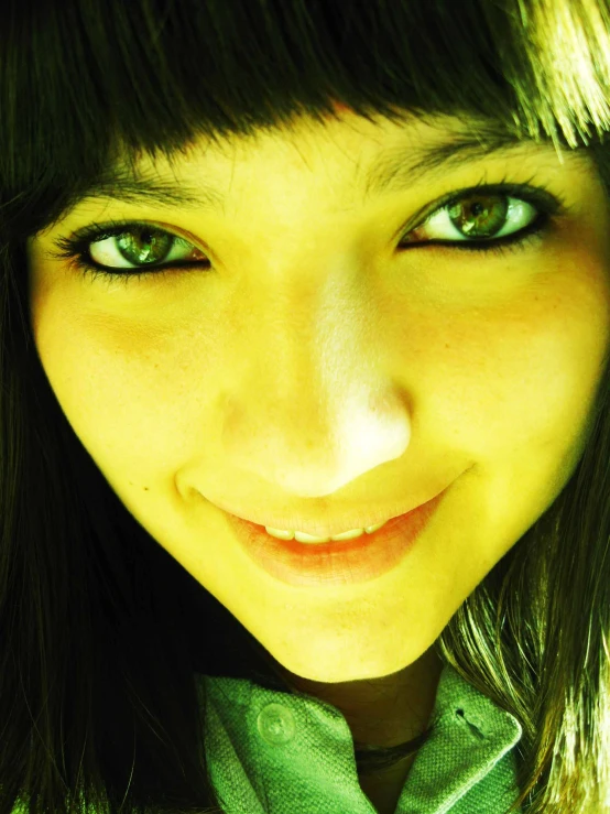 a girl with green eyes smiling while wearing a green shirt and tie