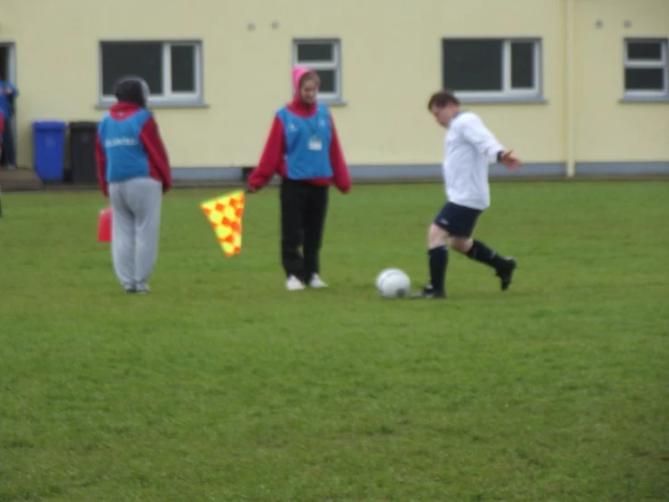 a couple of people on a field with soccer balls