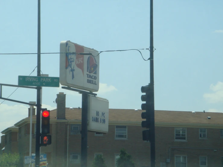 a stop light is lit with street signs beside it