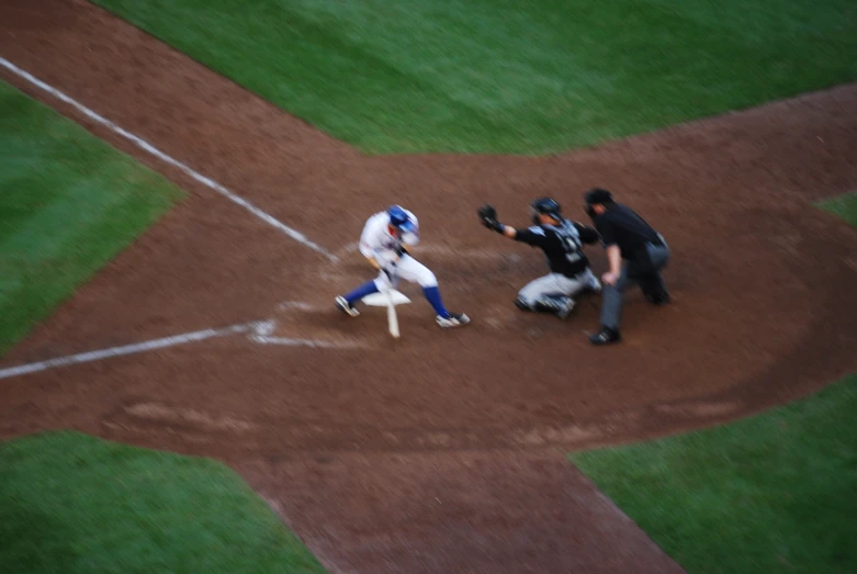 three people playing baseball one has on a red jersey and one has blue and white shorts