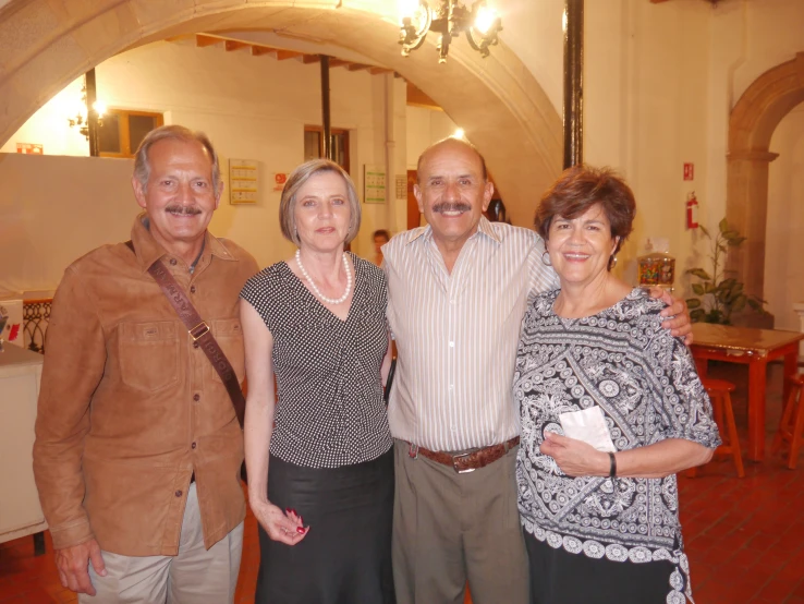 four adults posing for a picture in a banquet hall