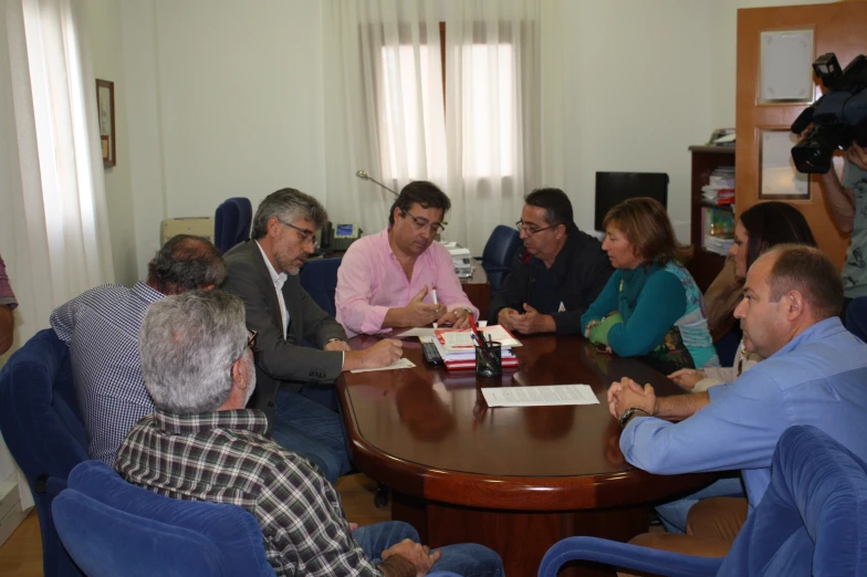 the men are sitting at a table during an discussion