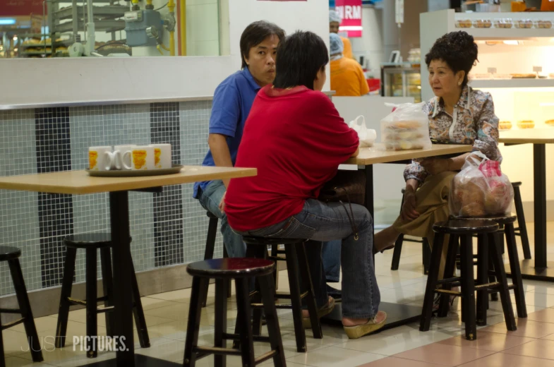 three people sitting at a table in a restaurant