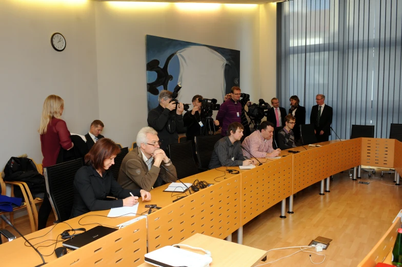 several people sitting at desks listening to a presentation