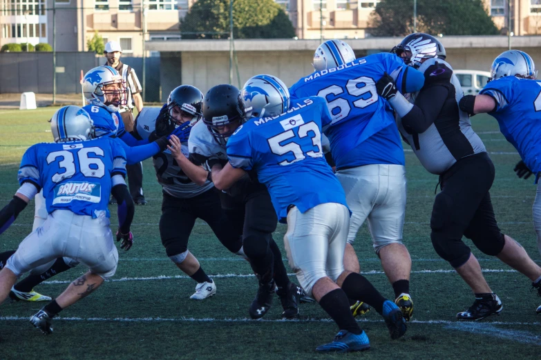 several football players in blue and white jerseys, with one of them holding the ball