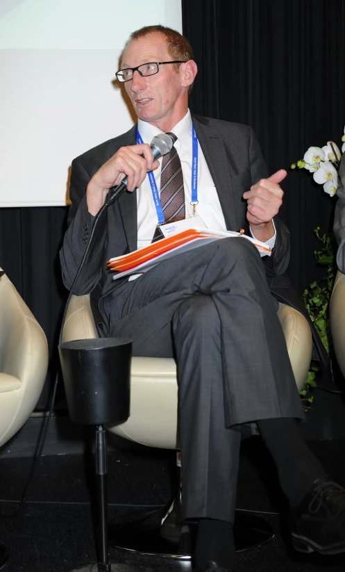 a man sits on a chair while talking