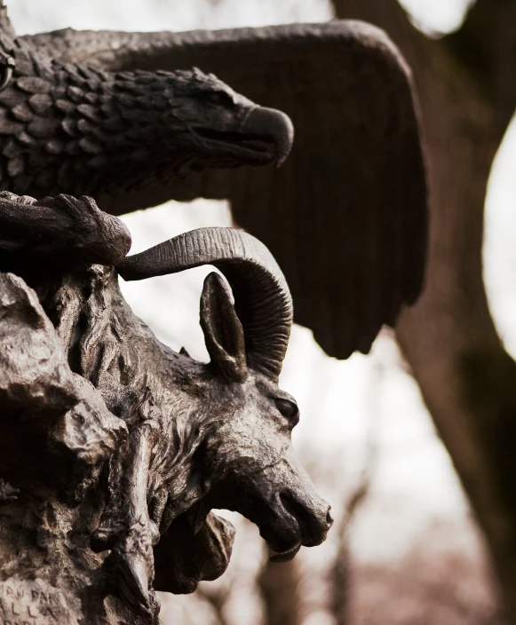 an eagle and horned animal statue with wood carving