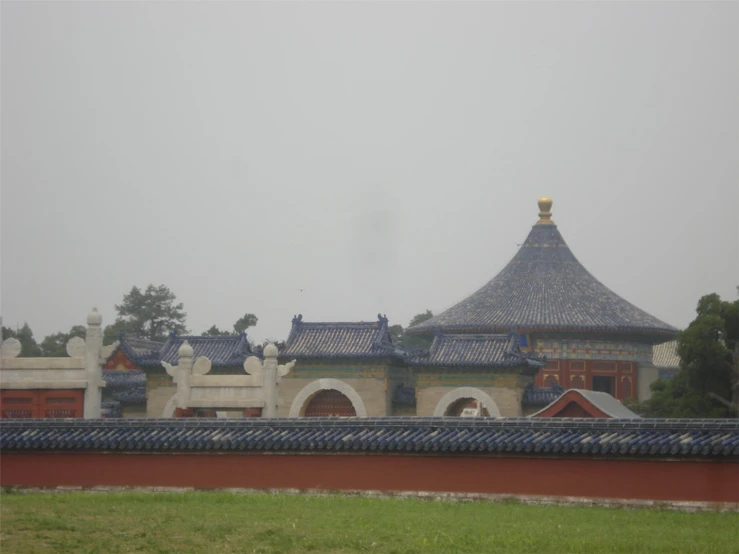 a tall building with a blue roof sitting under a cloudy sky