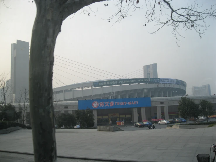 a view of a parking lot with a blue sign in the foreground and an image of an empty building in the background