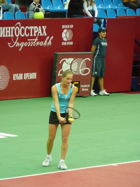 a young lady prepares to serve a tennis ball