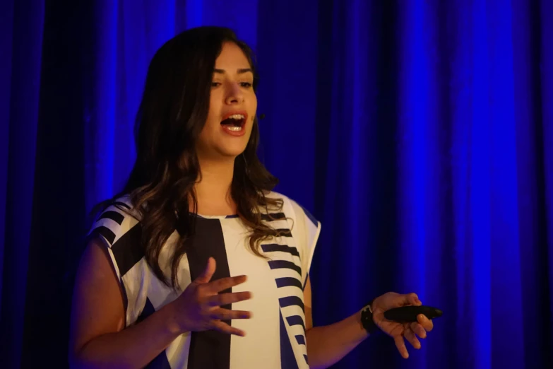 a woman speaking on stage during an audience