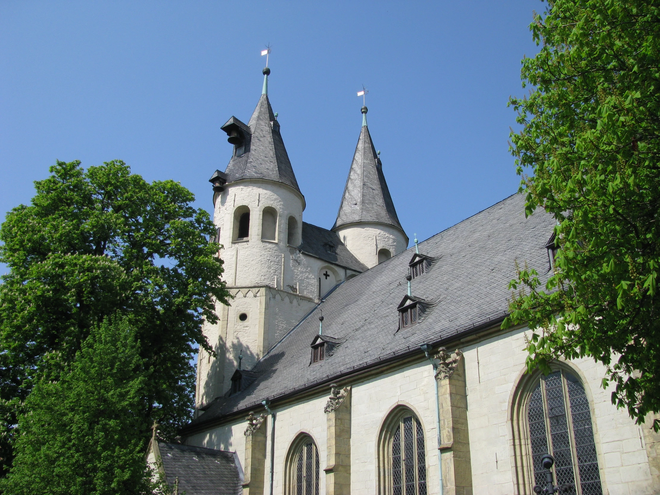 an old church with a steeple next to trees