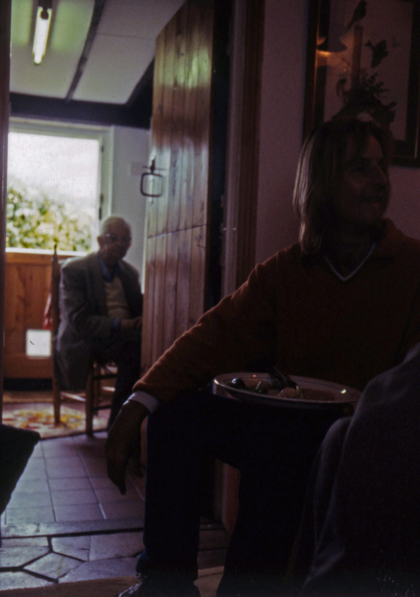 a man and his daughter in the background with a drink on a table