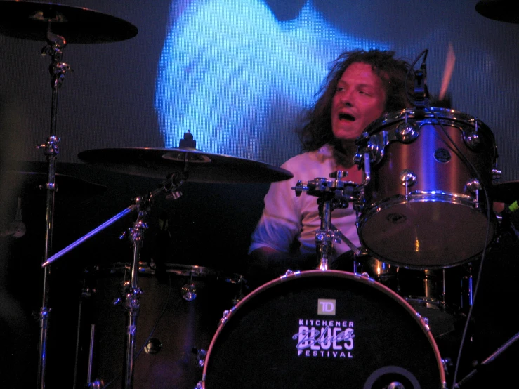 a man sitting behind a drumet on top of a stage