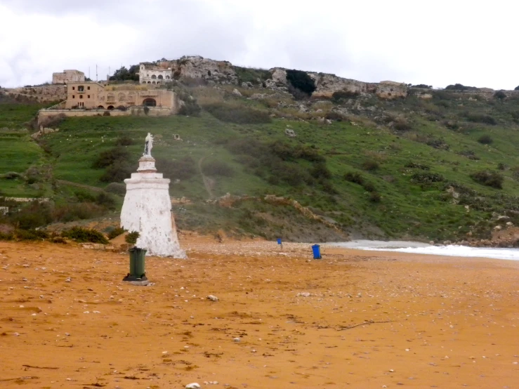 a mountain that has a white statue on top