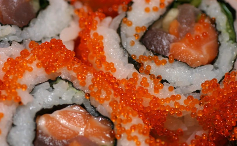a close - up po of some sushi with different colored sauces