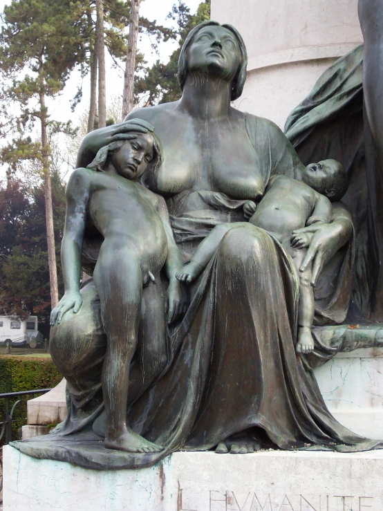 a woman with a child sits on a monument