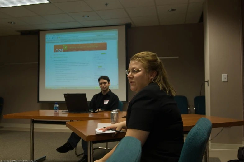 two people in front of a large projection screen