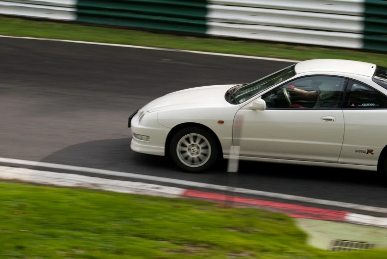 a white sports car speeding down a road