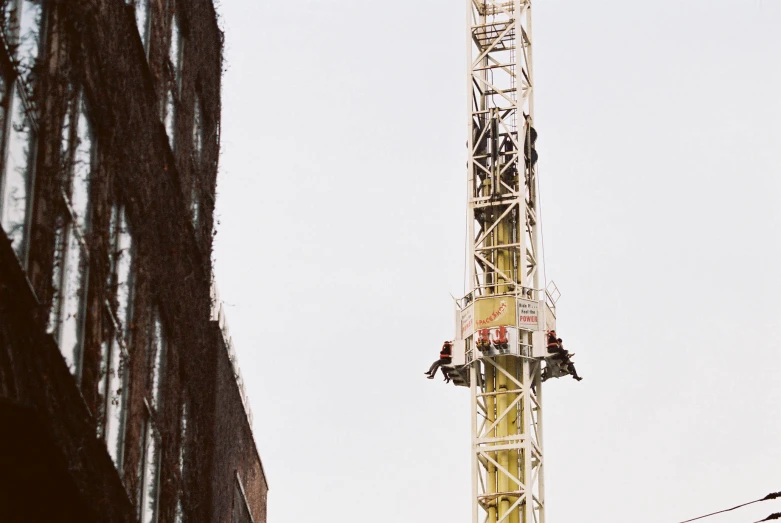 a tall white crane sitting next to a high rise building