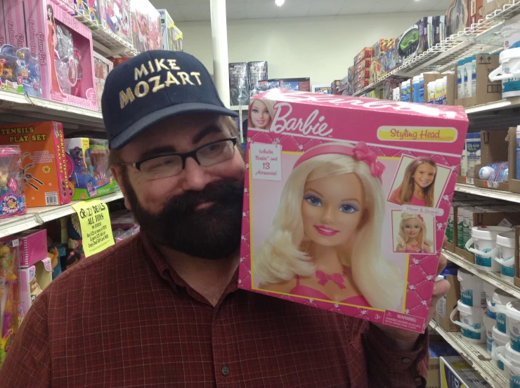 the bearded man is holding a barbie package in the store