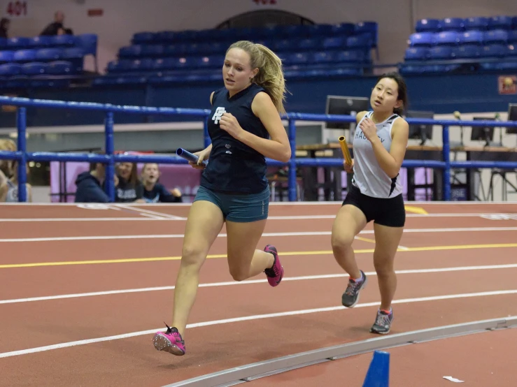 two girls running on the track in competition