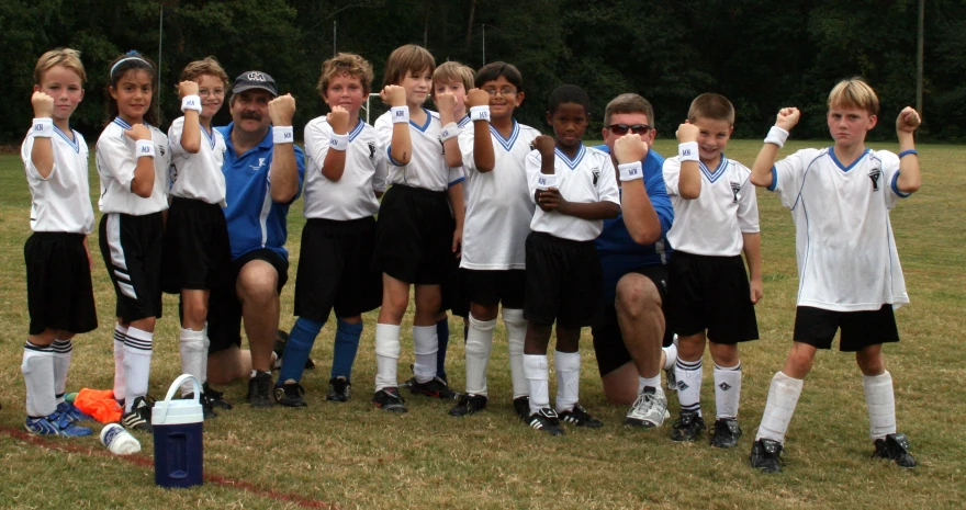 several boys and girls with their hands up to show them the sign