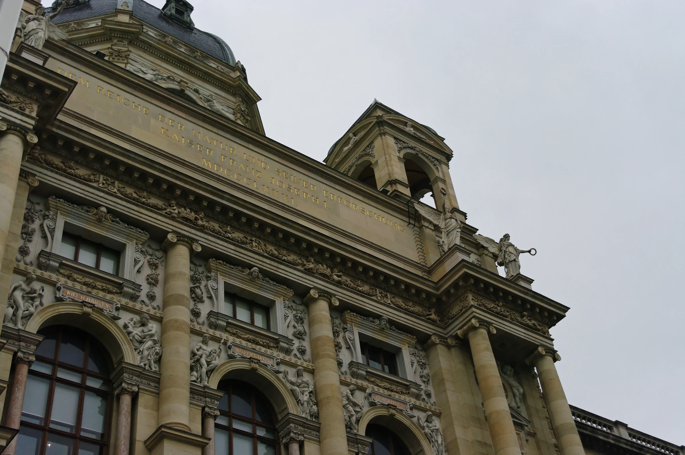 an old building with stone pillars and statues on top