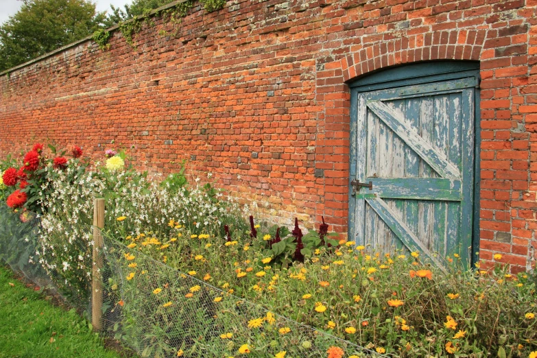 brick wall with flowers and fence surrounding it