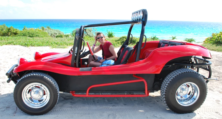 a man driving an red cart with a dog inside