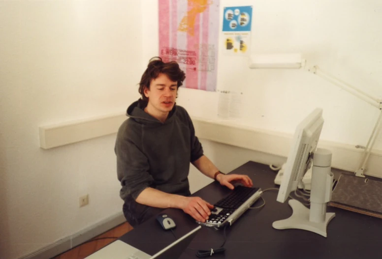 a young man uses a laptop computer at his desk