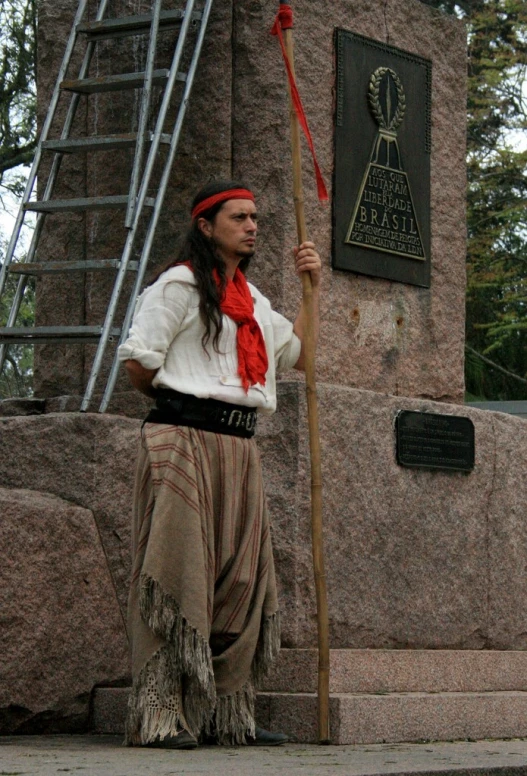 the native american girl holds a stick and wearing a headdress