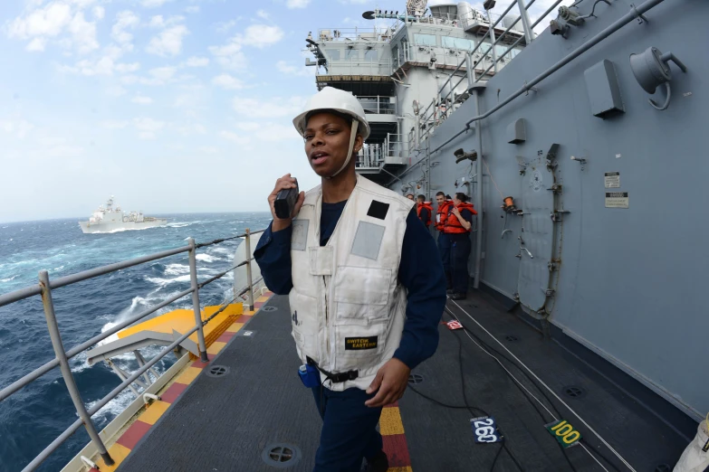 a man in blue pants on the deck of a ship